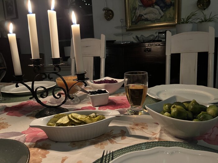 Dukat bort med tända ljus, inlagd gurka, brysselkål och glas med dryck, redo för gåsamiddag.