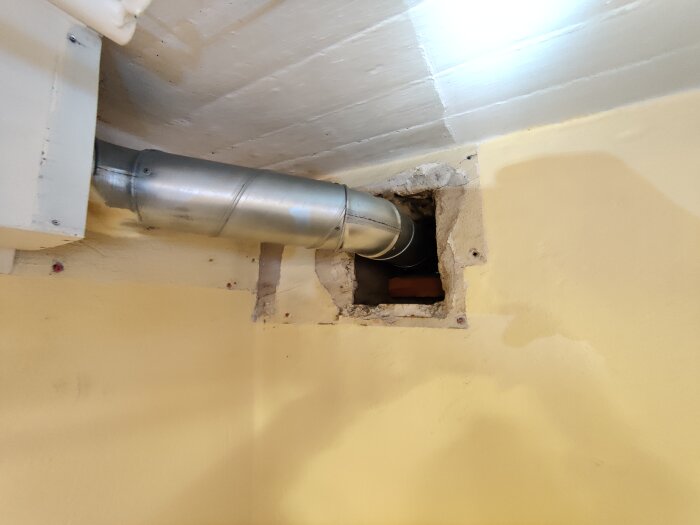 Ventilationskanal i innervägg med plåtrör anslutet till hål i yttervägg.