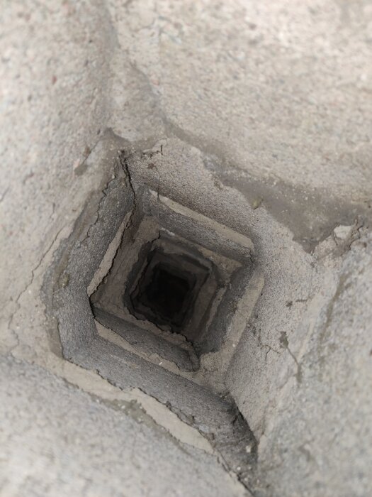 Rektangulär kanal synlig genom en vägg, troligen ett ventilationsschakt blottlagt under renovering.