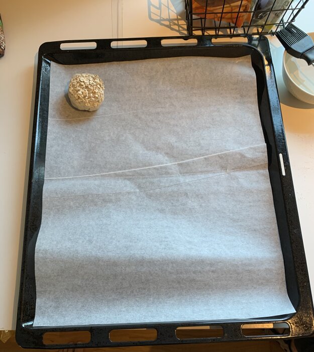 En havregrynsfralla ligger på en plåt med bakplåtspapper, redo att gräddas.