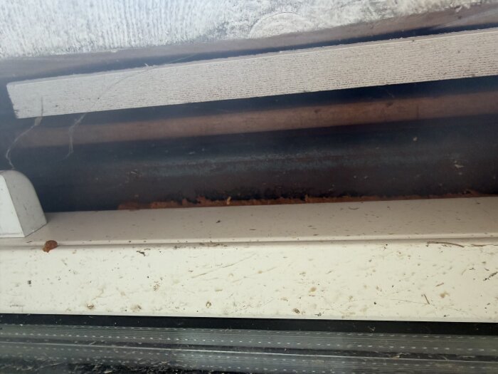 Väggens utsida med synlig panel, stål och glasdelar som visar isoleringsavstånd.