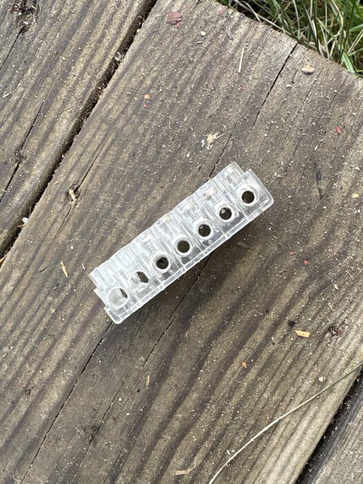 En genomskinlig kopplingsplint ligger på en träyta, används istället för en Wago-koppling.