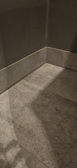 Hörn av toalett med klinkergolv, 8cm lister mot väggen, fogad med silikon för ren och snygg finish.