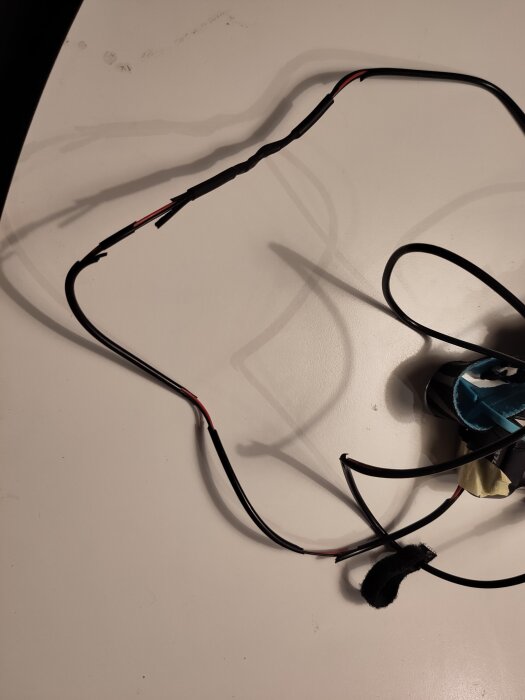 Sladd som är delvis upplöst och trasig, från en gammal pannlampa, mot en ljus bakgrund.