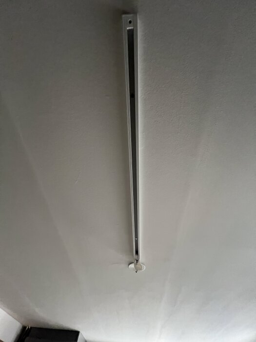 Takmonterad skena för spotlights utan lampor, del av ett pågående projekt av elektriker.