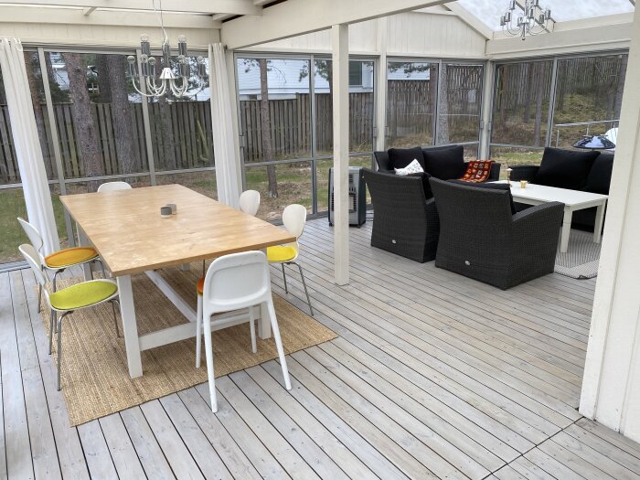 Uterum med pelare mitt i rummet, bord med stolar och soffa i bakgrunden.