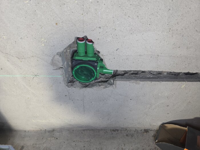 Elektrisk installation i hålstensbetongvägg med nylagd multifix-dosa och flexrör, del av renoveringsprojekt för eluttag.