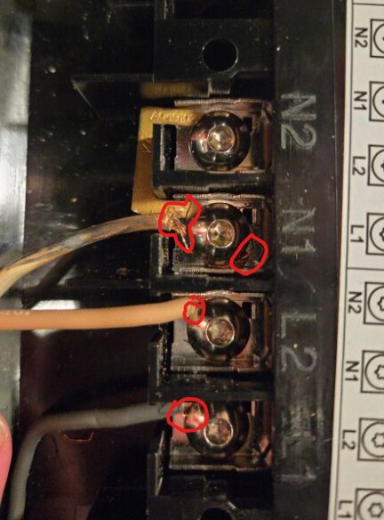 Elektrisk kopplingsplint med flera anslutningar och kablar, några markerade med röda cirklar, ser inte ut att vara korrekt anslutna.