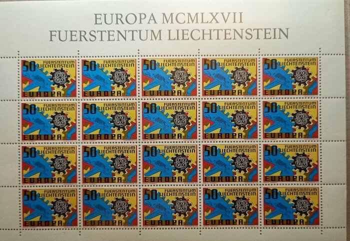 Ark med 20 färgglada Liechtenstein-frimärken från 1967, dekorerade med kugghjul och geometriska former.