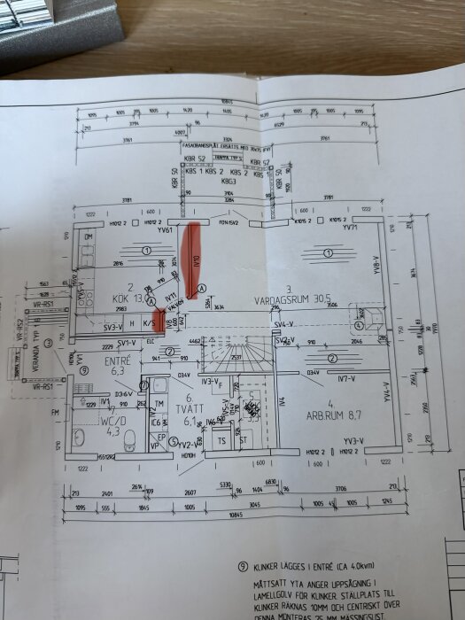 Ritning av bottenplan med markerade väggar och mått, inkluderar kök, vardagsrum, entré, tvätt och WC. Fråga om bärande element.