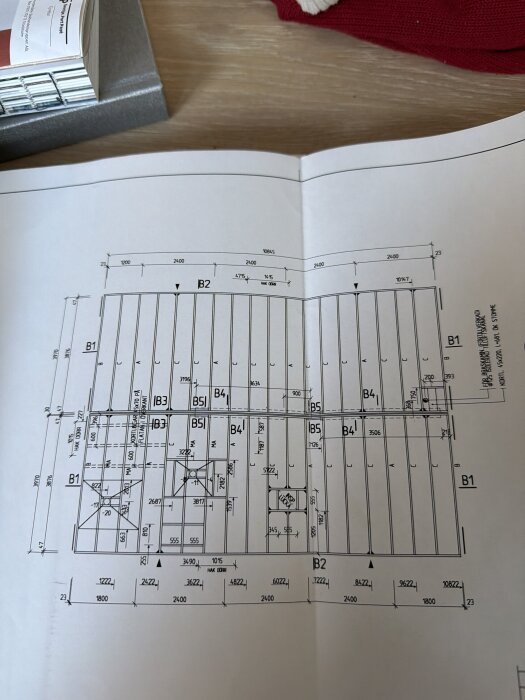 Byggnadsritning med mått och markeringar för botten- och mellanbjälklag, med frågetecken kring vilka väggar som är bärande.