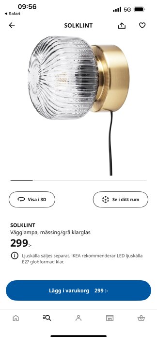 Vägglampa IKEA Solklint i mässing och klarglas visas med svart kabel, säljs för 299 kr.