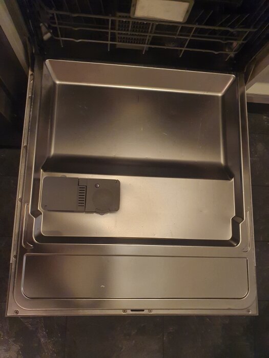 Öppnad diskmaskin med synlig insida av dörren och diskmedelsfack i fokus.