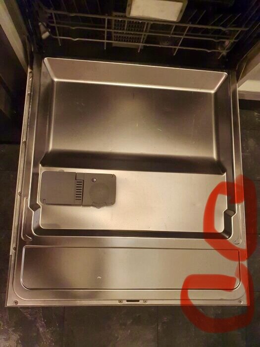 Diskmaskinens insida med markerad skruvplats för att lossa luckan.