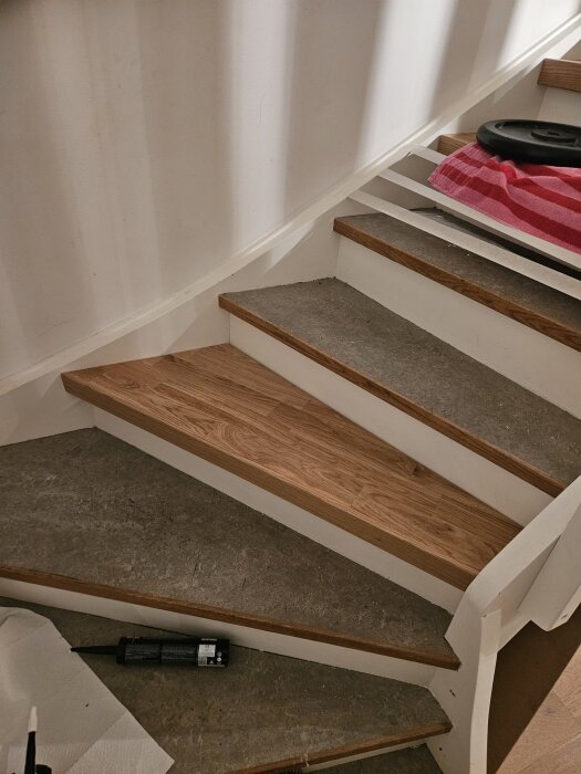 Nya ektrappnosar installerade på trappsteg, med liten överhängning och verktyg och material synliga runt omkring.