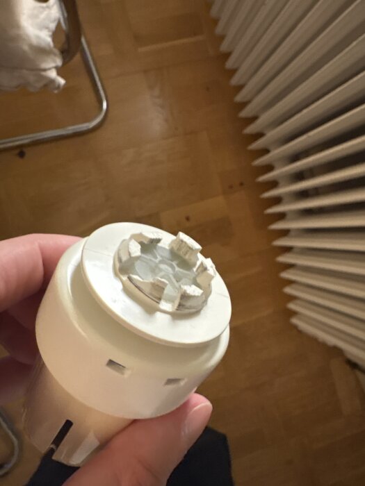 Hand som håller en vit termostatdel nära ett element, diskuterar adapterproblem med MMA 16 till M30x1,5 adaptrars passform.