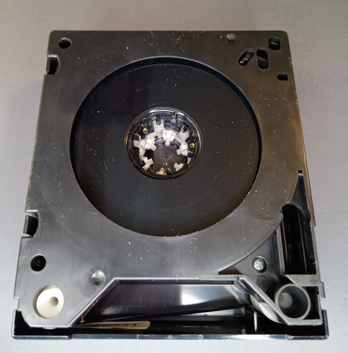 Svart VCR-kassett från Philips, tidigt videobandformat från 1972, med ett runt fönster i mitten som visar bandmekanismen.