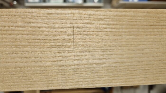 Träbräda med en inritad linje, potentiellt för att markera plats för att såga ut ett lådförstycke.