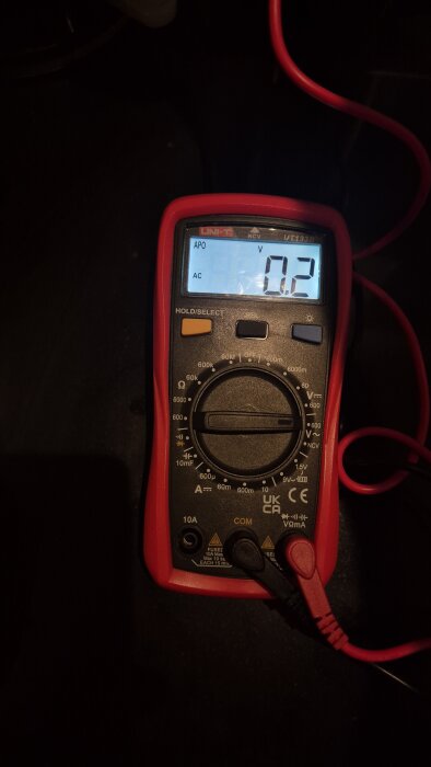 Digital multimeter visar 0.2 V AC på displayen, inställd på växelström 600 V, med svarta och röda testsladdar inkopplade.