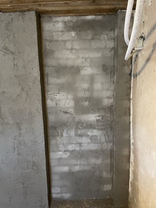 Vägg under renovering, delvis putsad med Combimix putsbruk.