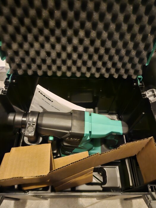 HiKOKI-verktyg i sin förpackning med manual och skyddande skum.