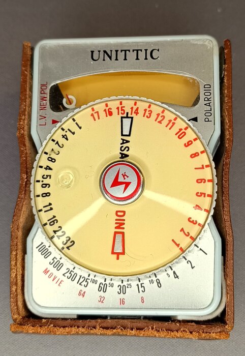 Exponeringsmätare med selencell, märkt "Unitic", med numeriska inställningar och en läderomslutning.
