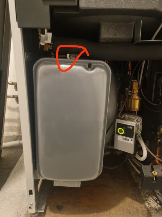 Expansionskärl i panna med ett rött streck markerande var du tömmer och lossar för att ta ut kärlet.