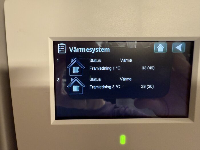 Bild på display som visar status på värmesystem: Framledning 1 har 33°C (mål 49°C), Framledning 2 har 29°C (mål 30°C).