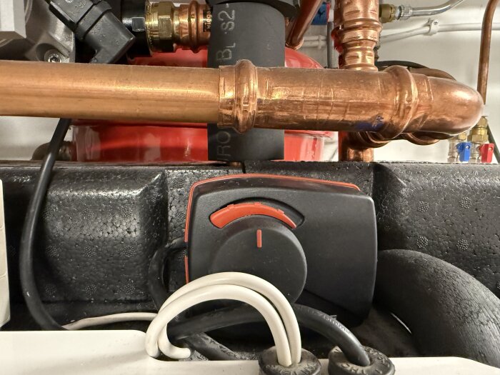 Shuntmotor och kopparrör i en värmepumpinstallation.