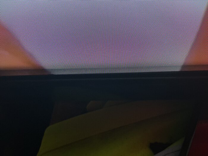 Närbild av tv-skärm med möjliga dammpartiklar synliga inuti och oskarp bildkvalitet.