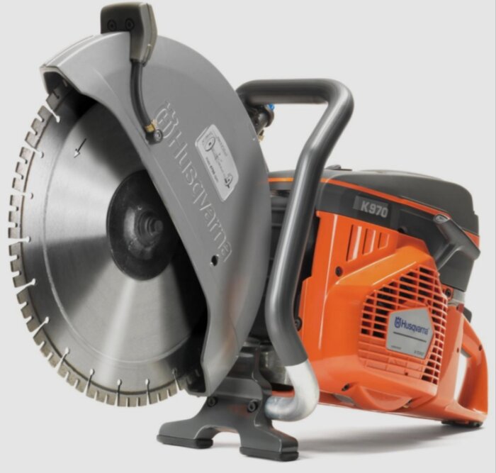 Bensindriven Husqvarna K970 kapsåg med orange och grå design, lämplig för kapning i byggprojekt.