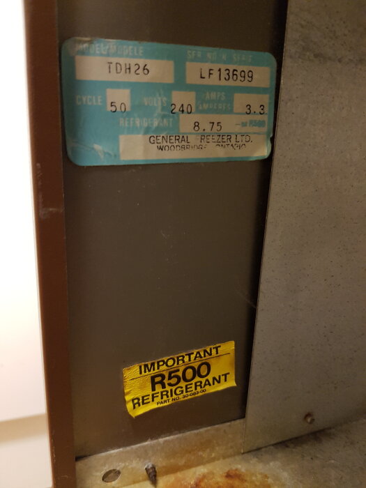 Etikett på kylsystem från General Freezer Ltd, modell TDH26, med köldmedium R500 angivet på gul varningslapp.