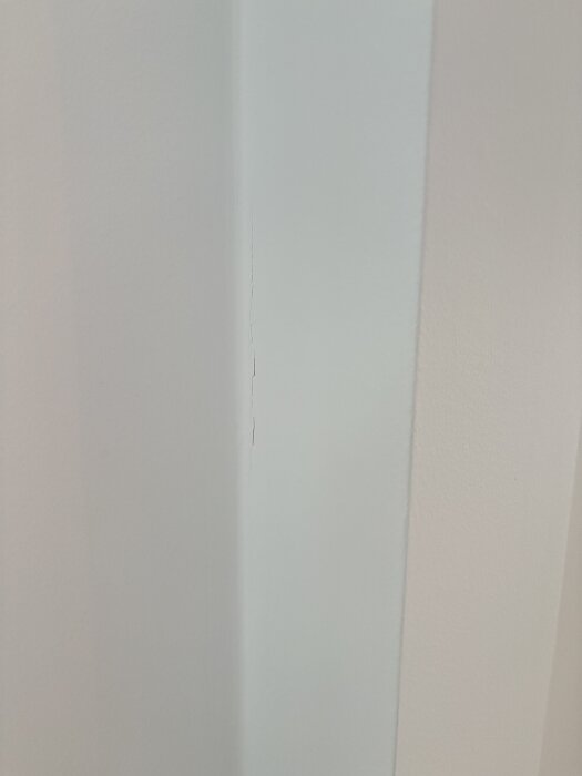 En närbild av en skarv mellan två väggar med en synlig spricka.