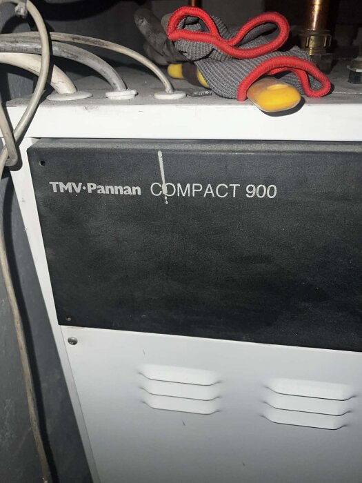 En TMV-Pannan Compact 900 med verktyg och handskar ovanpå, där användaren söker information om elpatronens placering och inköp.