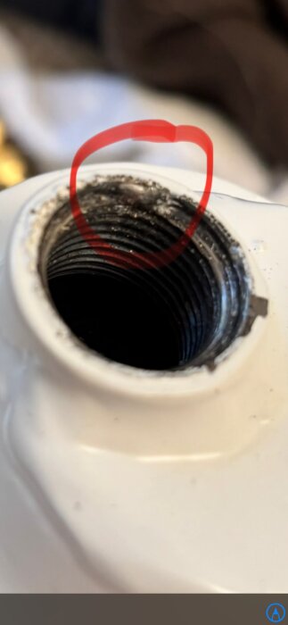 Nära bild på ett gängat plugghål i ett Lenhovda Rex element med fabriksdefekt, markerad med en röd cirkel.