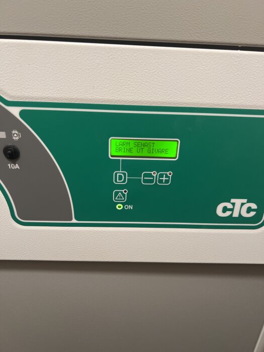 Display på en CTC panna visar texten "LARM SENAST BRINE UT GIVARE" och har en grön bakgrund med CTC-logotyp.