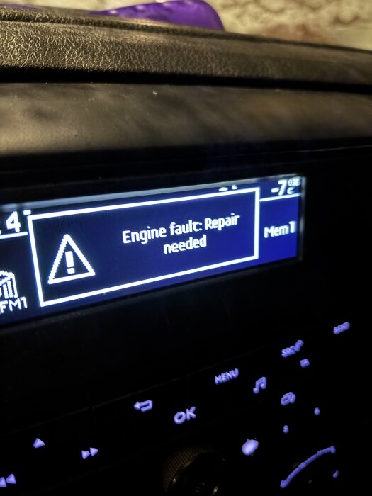 Bilens display visar "Engine fault: Repair needed" och utetemperaturen är -7°C.