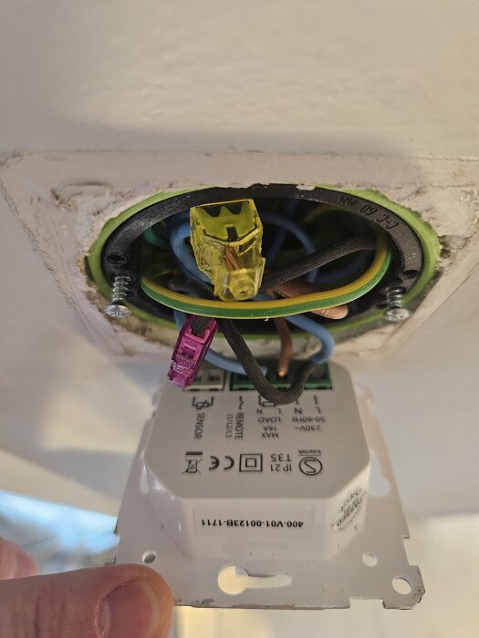 Elektrisk installation med flera kablar anslutna och en gul kopplingsklämma i takdosa, relaterad till golvvärmeproblem.