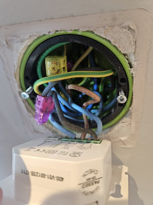 Elskåp med flera kablar i olika färger samlade med kopplingshattar, del av golvvärmesystem.