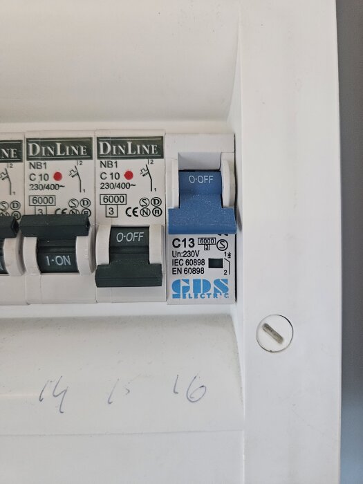 Bild av en elcentral med fyra strömbrytare, varav en blå strömbrytare i läge O-OFF. Markerade nummer 14, 15, 16 finns nedanför.