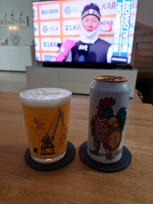 Ölglas och burk på ett bord framför en TV som visar en skidåkningsintervju.