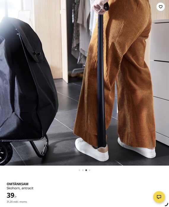 Person använder IKEA skohorn i kraftig metall för att ta på vita sneakers.