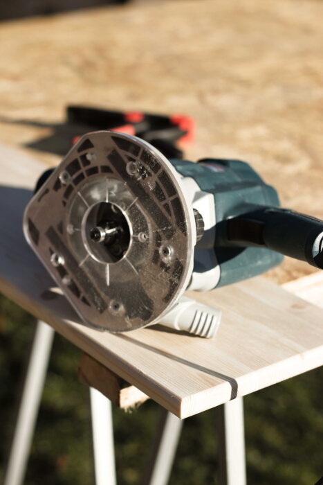 Handöverfräs på ett furubräde under tillverkning av ett skrivbord.