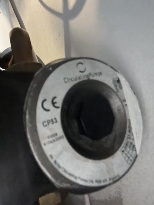 Cirkulationspump av modell CP53 med etikett, delvis skuggad rörledning synlig i bakgrunden.