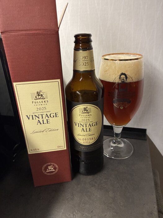 Flaska och glas med Fuller's 2025 Vintage Ale, bredvid ligger förpackningen.