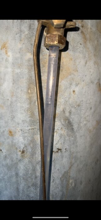 Nytt och gammalt plaströr monterat på en vägg i samband med vattentrycksproblem.