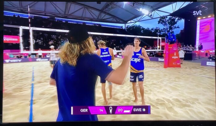 Svenska volleybollspelare firar seger mot Tyskland med 20-14 poäng i en sandvolleybollmatch under en turnering.
