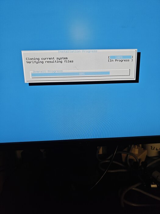 Skärmvisning av installationsprocess med 80% framsteg, kloning av system och verifiering av filer visas på blå bakgrund.