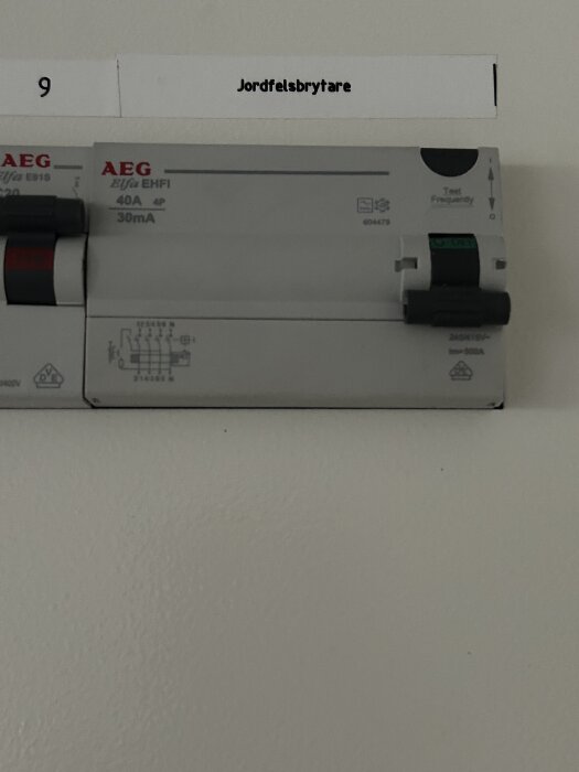 Jordfelsbrytare från AEG med etikett på en vägg.