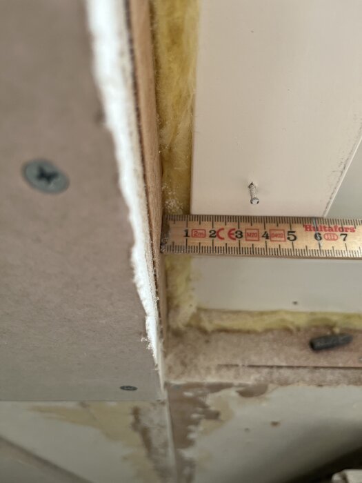 Mätning av avståndet mellan fönsterkarm och regel med linjal, visar variation mellan 11 och 14 mm.